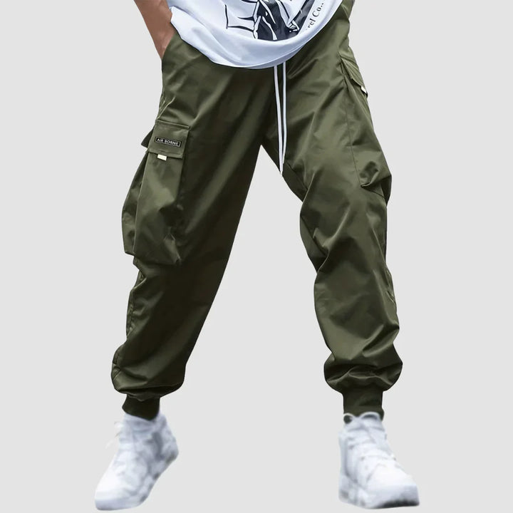 Mężczyzna w modnych spodniach cargo męskich w ruchu. Casualowy look, komfortowe na co dzień, kolor granatowy.