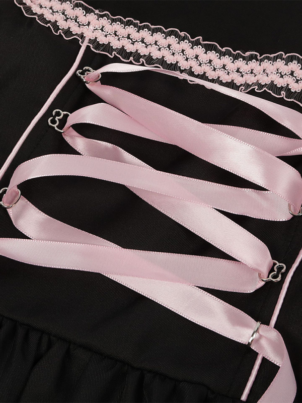 Detal czarnej sukienki dirndl: kwiatowy wzór, zdobienia gorsetu i spódnicy.