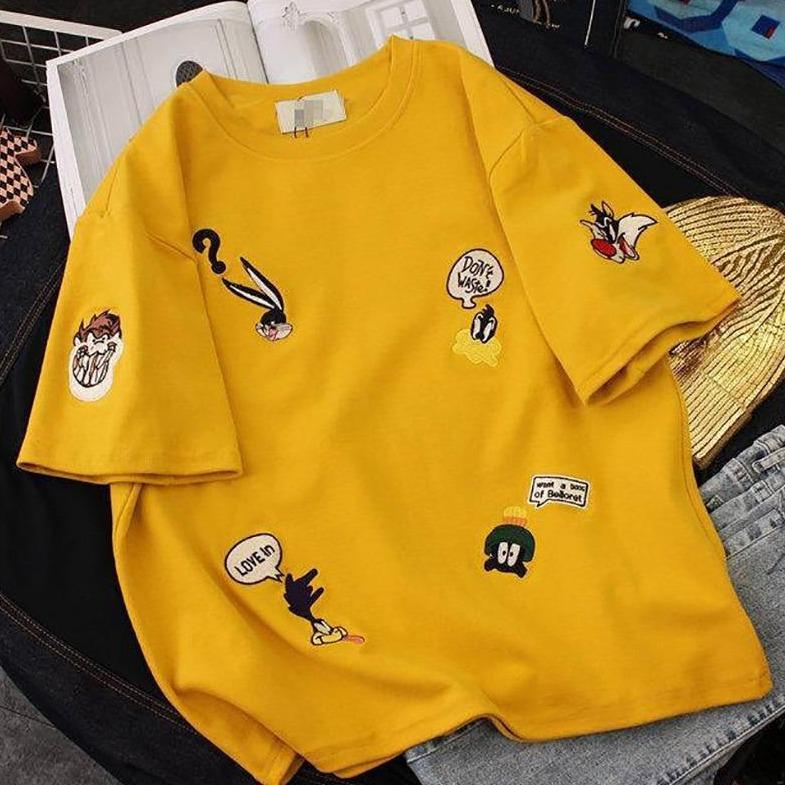 Modna damska koszulka T-shirt oversize z motywem kreskówkowym, dostępna w kolorach białym, żółtym i czarnym.