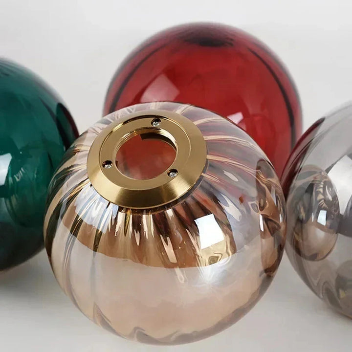 Lampa wisząca Art Deco w kolorze złotym. Szklany kulisty klosz. Eleganckie oświetlenie jadalni.
