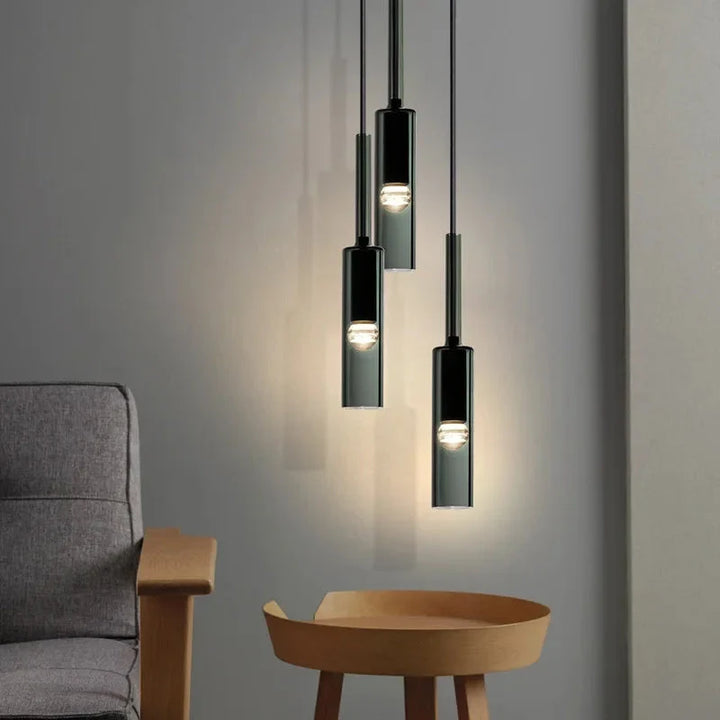 Stylowa lampa wisząca z cylindrycznym kloszem szklanym, czarna oprawa. Oświetlenie sufitowe do jadalni.