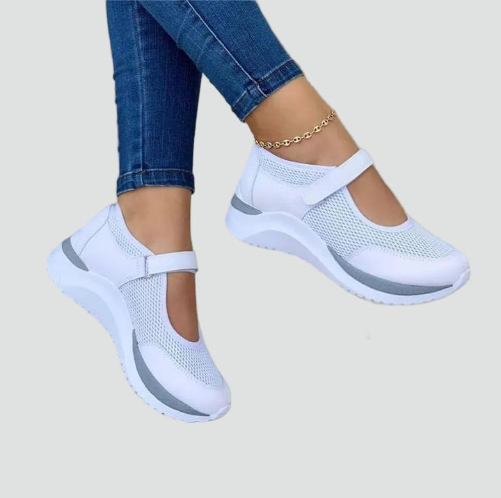 Zbliżenie na damskie sneakersy z wygodnymi rzepami, zapewniającymi szybkie zakładanie. Dostępne w bieli i czerni.