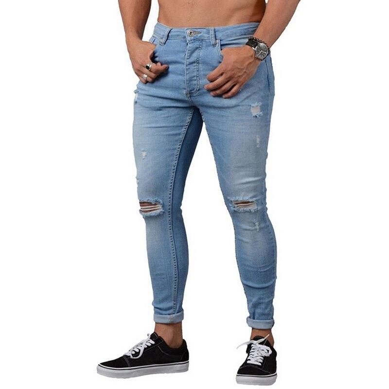 Niebieskie męskie jeansy slim fit z modnymi przetarciami. Komfortowe spodnie do męskich, miejskich stylizacji.