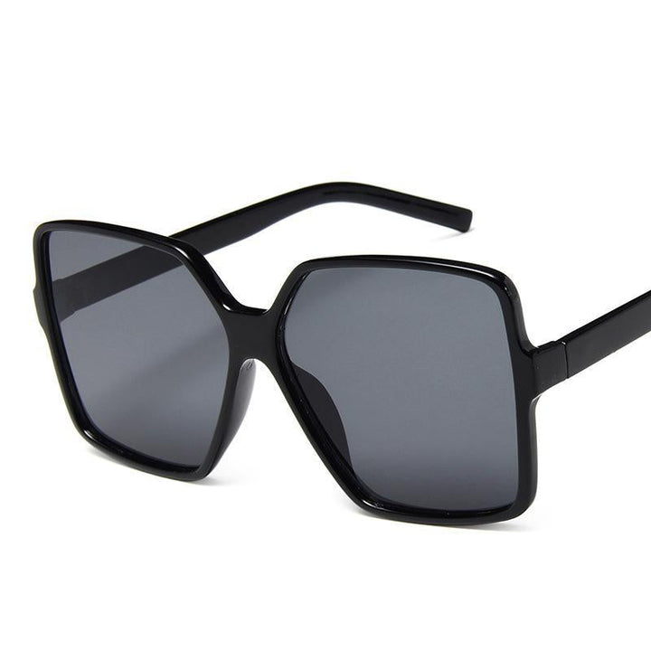 Czarne prostokątne okulary przeciwsłoneczne damskie z filtrem UV. Eleganckie i modne akcesorium na lato.