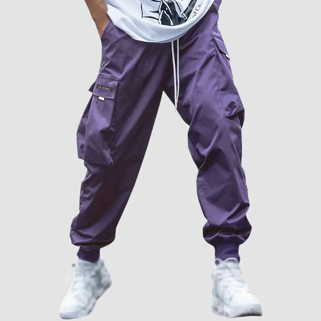 Zbliżenie na pojemne kieszenie boczne męskich spodni cargo. Funkcjonalny i modny detal, idealne do streetwearu.
