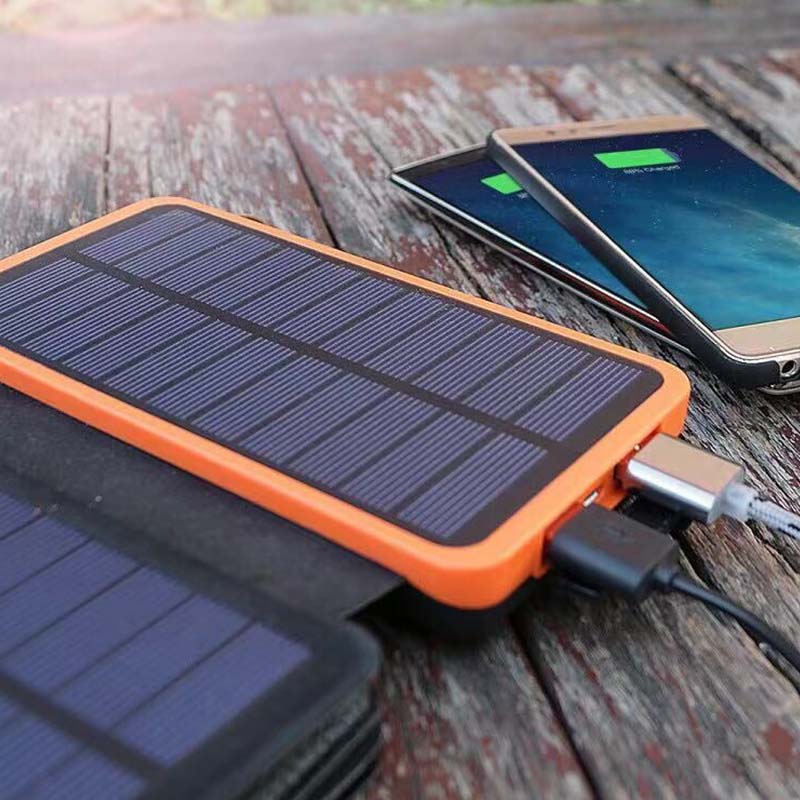 Powerbank solarny SunCore z kablem USB, gotowy do ładowania smartfonów i tabletów na wakacjach.