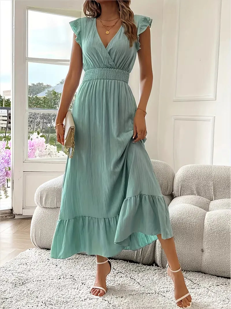 Elegancka damska sukienka maxi na wesele, kopertowy dekolt, falbana. Długa, wieczorowa kreacja.